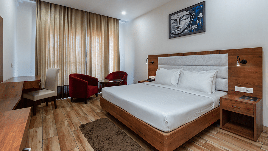A Club Balcony Room featuring a bed, a teapoy and chairs at DLS The Classio